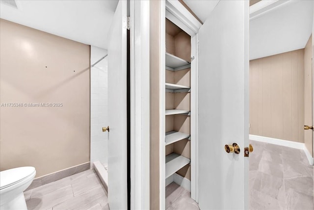 bathroom featuring walk in shower and toilet