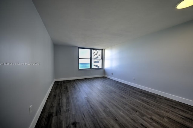 unfurnished room with dark hardwood / wood-style flooring