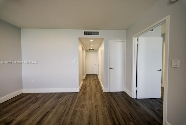 hallway with dark hardwood / wood-style flooring