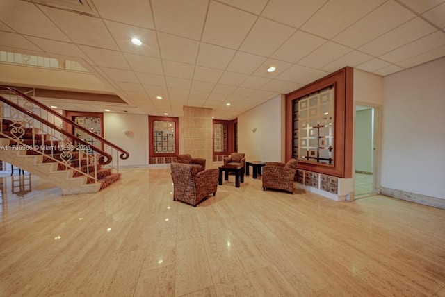 unfurnished living room with hardwood / wood-style floors and a drop ceiling