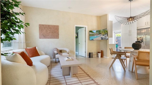 living room featuring light speckled floor and baseboards