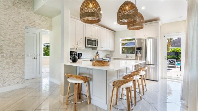 kitchen with stainless steel appliances, plenty of natural light, sink, and backsplash