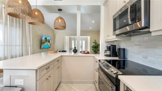 kitchen featuring light countertops, decorative backsplash, appliances with stainless steel finishes, a peninsula, and white cabinets