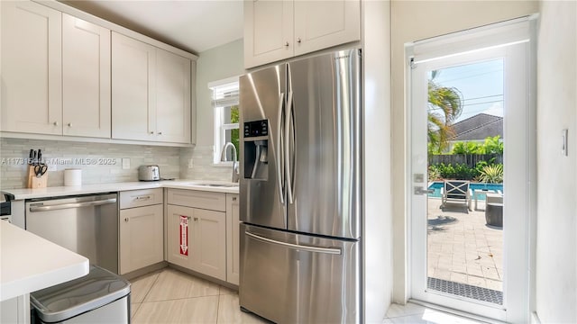 kitchen featuring tasteful backsplash, stainless steel appliances, light countertops, and a wealth of natural light