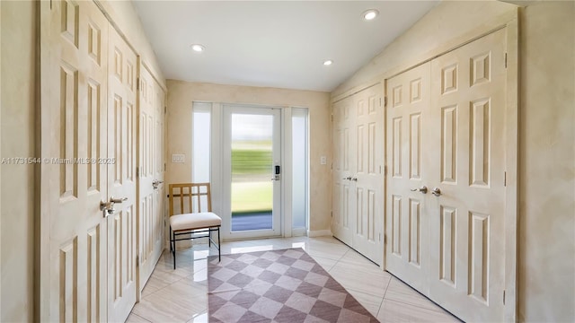 interior space featuring lofted ceiling, light tile patterned floors, and recessed lighting