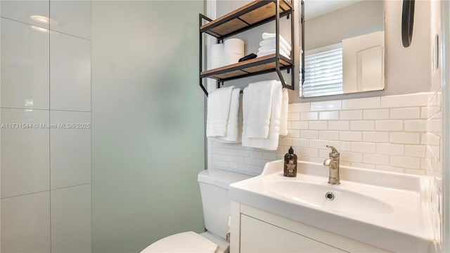 bathroom featuring vanity, decorative backsplash, and toilet