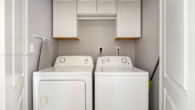 clothes washing area with cabinet space and separate washer and dryer