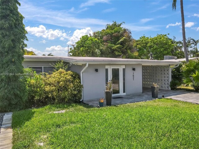 rear view of property featuring a lawn