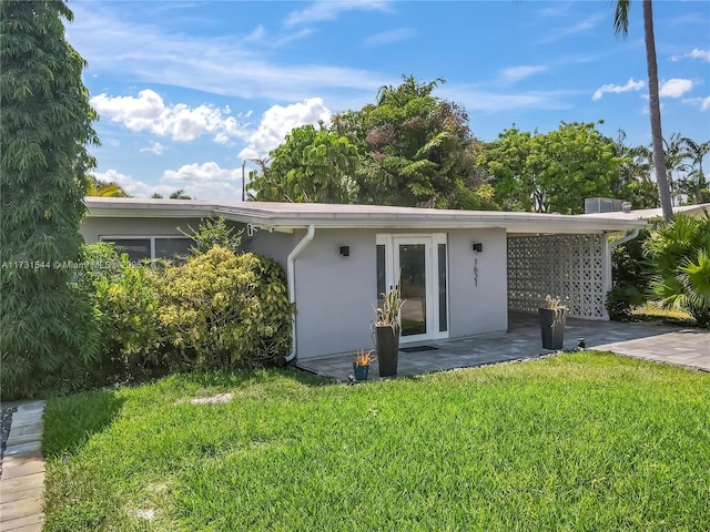 view of front of house featuring stucco siding and a front lawn