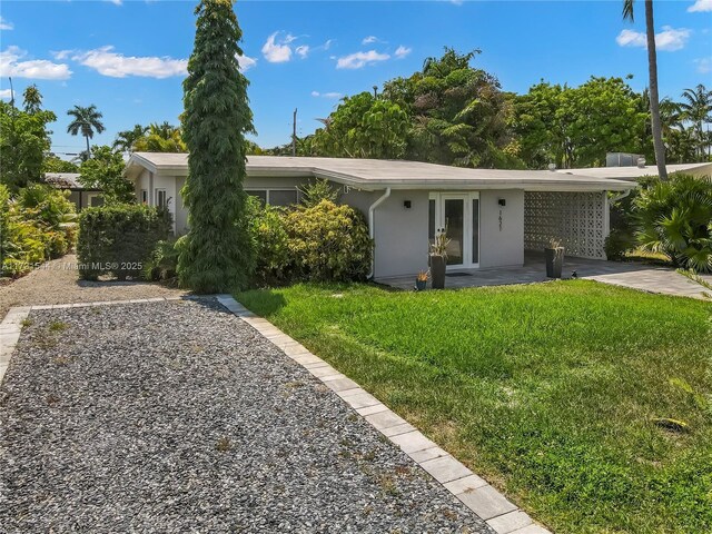 ranch-style home featuring a carport and a front lawn