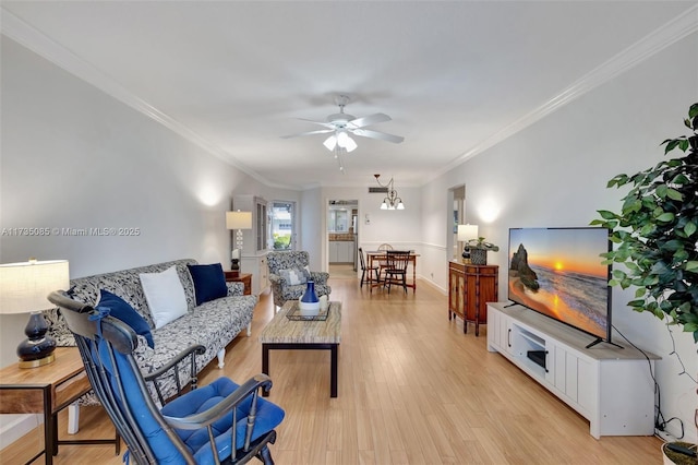 living room with crown molding, light hardwood / wood-style flooring, and ceiling fan