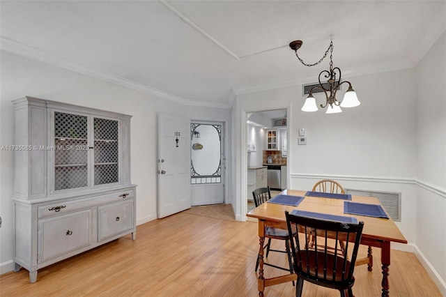 dining space featuring a notable chandelier, crown molding, and light hardwood / wood-style flooring