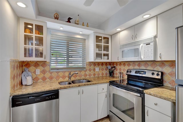 kitchen featuring appliances with stainless steel finishes, sink, white cabinets, and light stone counters