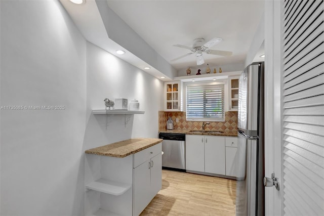 kitchen featuring sink, ceiling fan, white cabinetry, backsplash, and stainless steel appliances