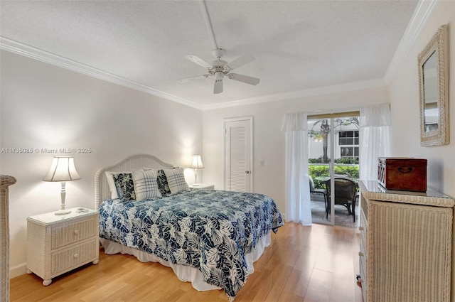 bedroom featuring access to exterior, crown molding, wood-type flooring, and a textured ceiling