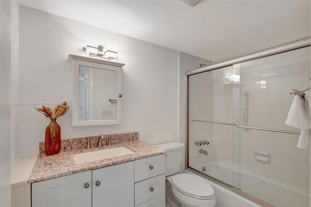 full bathroom featuring toilet, vanity, and shower / bath combination with glass door