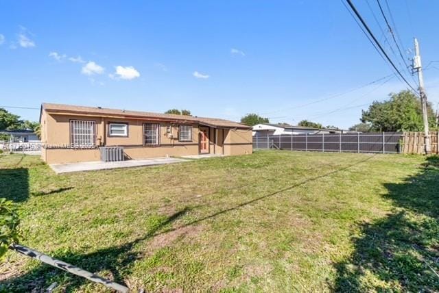 rear view of property featuring a lawn