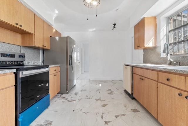 kitchen featuring appliances with stainless steel finishes, sink, backsplash, and light brown cabinetry