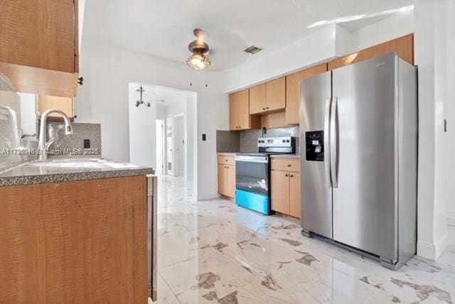 kitchen featuring sink, backsplash, stainless steel appliances, and ceiling fan