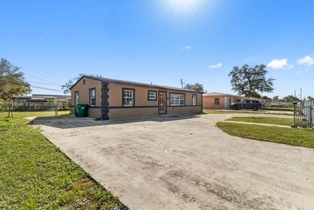 16025 NW 29th Ave, Miami Gardens, FL 33054 - view of front of home with stucco siding, a front lawn, and driveway