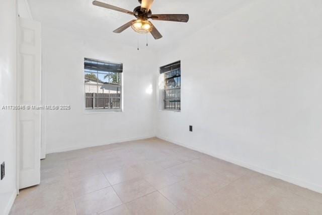 spare room featuring ceiling fan and light tile patterned flooring