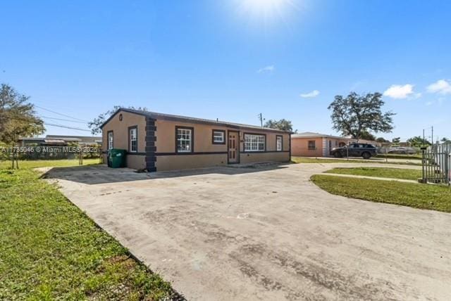 ranch-style house featuring a front yard and a carport