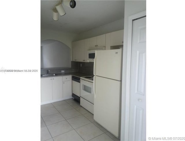 kitchen featuring sink, light tile patterned floors, white cabinets, and white appliances