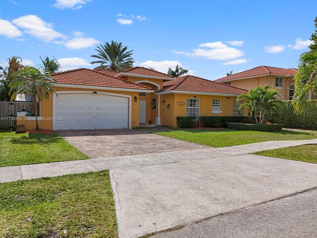 15804 SW 99th Ter, Miami, FL 33196 - mediterranean / spanish house featuring driveway, stucco siding, a front yard, and an attached garage