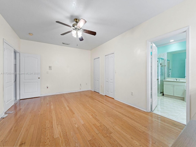15804 SW 99th Ter, Miami, FL 33196 - unfurnished bedroom featuring multiple closets, light wood-style flooring, ensuite bathroom, and a sink