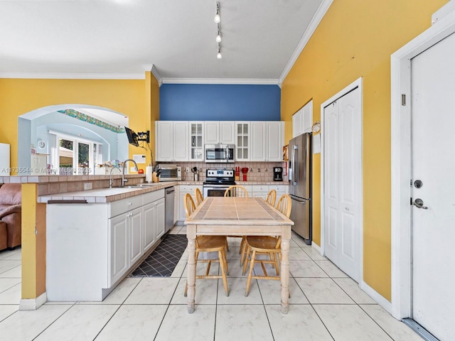 15804 SW 99th Ter, Miami, FL 33196 - kitchen featuring stainless steel appliances, a sink, a peninsula, white cabinetry, and backsplash