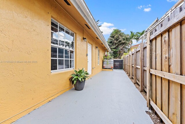 15804 SW 99th Ter, Miami, FL 33196 - view of property exterior with stucco siding, fence, and a patio area