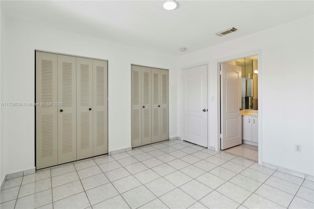 7011 W 29th Ave Unit 210, Hialeah, FL 33018 - unfurnished bedroom featuring two closets and baseboards