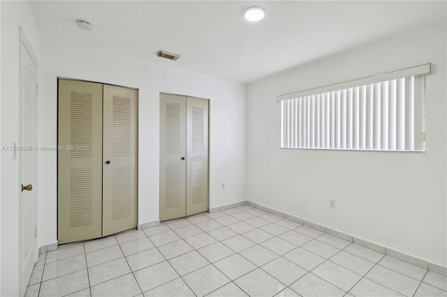 7011 W 29th Ave Unit 210, Hialeah, FL 33018 - unfurnished bedroom featuring multiple closets and light tile patterned floors