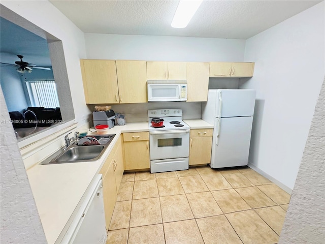 kitchen with sink, a textured ceiling, light brown cabinetry, and white appliances