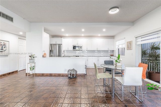 dining area featuring sink and a textured ceiling