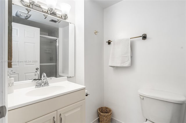 bathroom featuring walk in shower, vanity, and toilet