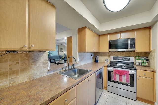 kitchen with stainless steel appliances, tasteful backsplash, sink, and light brown cabinetry