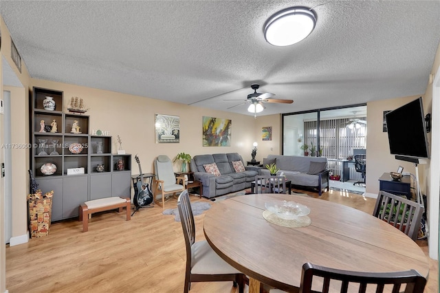 dining space with a textured ceiling, ceiling fan, and light hardwood / wood-style flooring