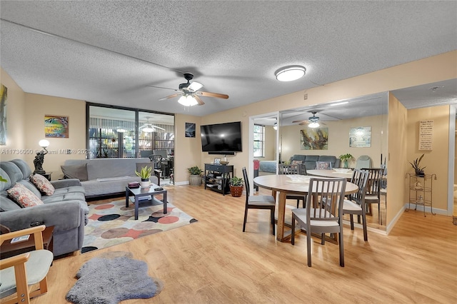 living room featuring ceiling fan, a textured ceiling, and light hardwood / wood-style floors