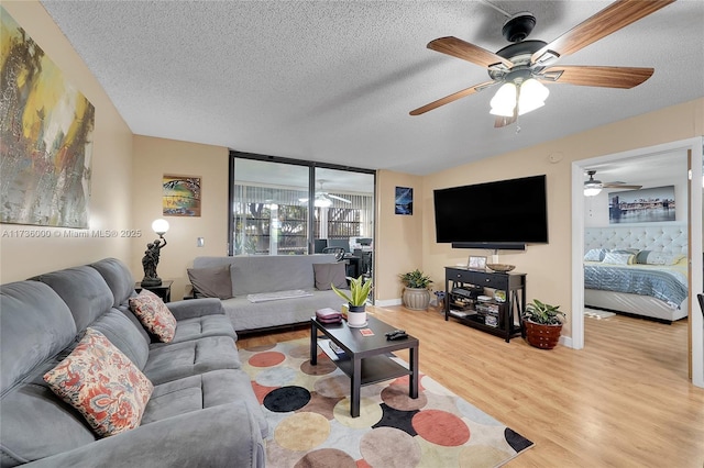 living room with a textured ceiling and light wood-type flooring