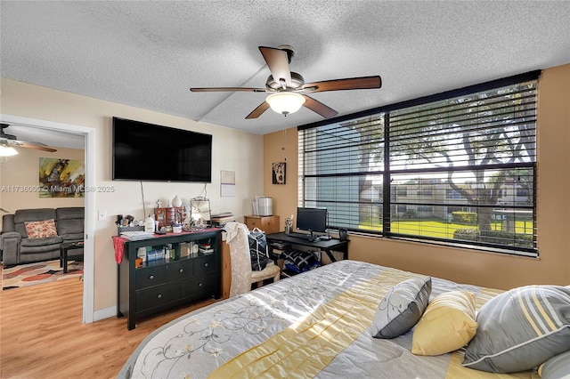 bedroom with wood-type flooring, ceiling fan, and a textured ceiling