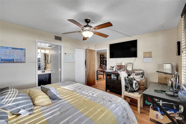 bedroom featuring ceiling fan, a textured ceiling, and light wood-type flooring