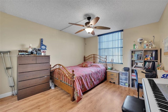 bedroom featuring ceiling fan, a textured ceiling, and light wood-type flooring