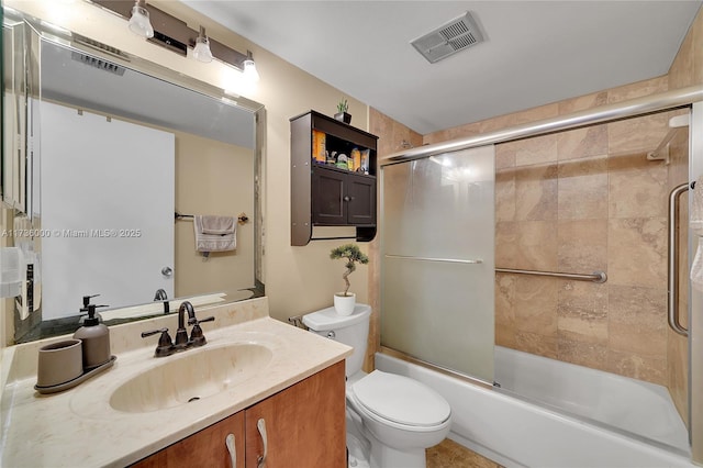 full bathroom featuring toilet, vanity, and bath / shower combo with glass door