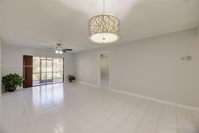 unfurnished room with light tile patterned flooring, ceiling fan, and a textured ceiling