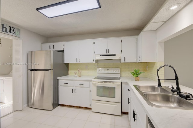 kitchen with electric stove, sink, stainless steel refrigerator, and white cabinets