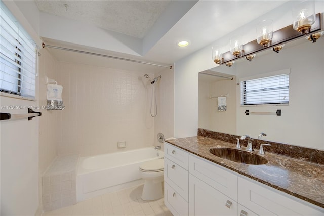 full bathroom featuring vanity, a textured ceiling, tiled shower / bath, tile patterned floors, and toilet