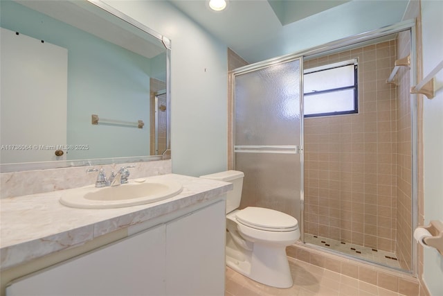 bathroom with tile patterned floors, vanity, toilet, and a shower with door