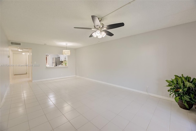 unfurnished room with ceiling fan, light tile patterned floors, and a textured ceiling