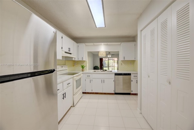 kitchen with stainless steel appliances, sink, white cabinets, and decorative backsplash